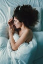 Caucasian woman lying in bed sleeping, her messy hair on pillow Royalty Free Stock Photo