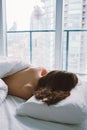 Caucasian woman lying in bed sleeping, her messy hair on pillow Royalty Free Stock Photo