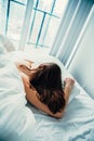 Caucasian woman lying in bed sleeping, her messy hair on pillow Royalty Free Stock Photo
