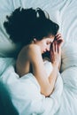 Caucasian woman lying in bed sleeping, her messy hair on pillow Royalty Free Stock Photo