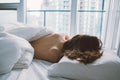 Caucasian woman lying in bed sleeping, her messy hair on pillow Royalty Free Stock Photo