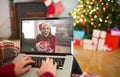 Caucasian woman making christmas laptop video call with smiling female friend holding gift Royalty Free Stock Photo