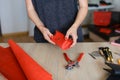 Caucasian woman making red leather wallet at atelier.