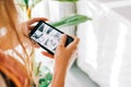 Caucasian woman monitoring security cameras on smartphone indoors, closeup Royalty Free Stock Photo