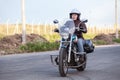 Caucasian woman motorcyclist riding on her chopper motorcycle on road