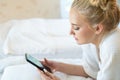 Caucasian woman in pajamas sleep alone in bed with loneliness. Typing message in smartphone Royalty Free Stock Photo