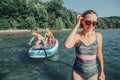 Caucasian woman parent riding kids children boys on paddle sup surfboard in water. Royalty Free Stock Photo