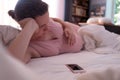 Caucasian woman with phone having labor contractions on sofa at home and breathing Royalty Free Stock Photo