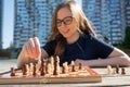 Caucasian woman playing chess outdoors. Royalty Free Stock Photo