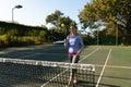 Caucasian woman playing tennis bouncing ball on racket on outdoor tennis court Royalty Free Stock Photo