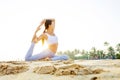 Caucasian woman practicing yoga at seashore of tropic ocean Royalty Free Stock Photo