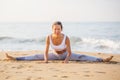 Caucasian woman practicing yoga at seashore of tropic ocean Royalty Free Stock Photo