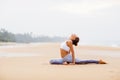 Caucasian woman practicing yoga at seashore of tropic ocean Royalty Free Stock Photo