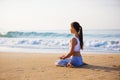 Caucasian woman practicing yoga at seashore of tropic ocean Royalty Free Stock Photo