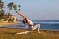 Caucasian woman practicing yoga at seashore of tropic ocean Royalty Free Stock Photo