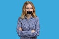 Caucasian woman protester with tape on mouth. Female activist protesting on color background.