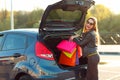 Caucasian woman putting her shopping bags into the car trunk Royalty Free Stock Photo