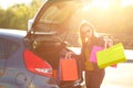 Caucasian woman putting her shopping bags into the car trunk Royalty Free Stock Photo