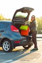 Caucasian woman putting her shopping bags into the car trunk Royalty Free Stock Photo