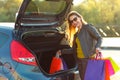 Caucasian woman putting her shopping bags into the car trunk Royalty Free Stock Photo
