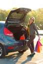 Caucasian woman putting her shopping bags into the car trunk Royalty Free Stock Photo