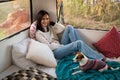 Caucasian woman is resting in a van with a Jack Russell Terrier dog. Traveling in a camper in autumn.