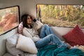Caucasian woman is resting in a van with a Jack Russell Terrier dog. Traveling in a camper in autumn.