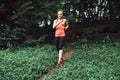 Caucasian woman running on forest trail wearing sport clothes. Royalty Free Stock Photo