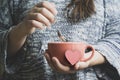 Caucasian woman`s hands holding a mug with some hot drink beverage with a paper heart shape. Social media relax Royalty Free Stock Photo