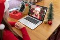 Caucasian woman in santa hat making laptop christmas video call with smiling female friend Royalty Free Stock Photo