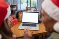 Caucasian woman and senior man having video call on laptop with copy space at christmas time Royalty Free Stock Photo