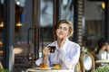 Caucasian woman sipping a hot espresso coffee while sitting outside the european style cafe bistro enjoying slow life with morning Royalty Free Stock Photo