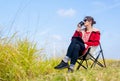 Caucasian woman sit on chair near meadow with blue sky and drink coffee with relax action in front of wind turbines or windmill Royalty Free Stock Photo