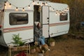 Caucasian woman sits in a van on a warm autumn day. Travel in a camper.