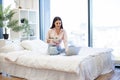 Caucasian woman sitting on comfy bed with wireless laptop, eating healthy salad Royalty Free Stock Photo