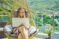 Caucasian woman sitting on the terrace working from home using computer laptop. Young woman teaches a foreign language Royalty Free Stock Photo