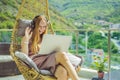 Caucasian woman sitting on the terrace working from home using computer laptop. Young woman teaches a foreign language Royalty Free Stock Photo