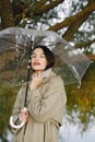 Portrait of a young woman in a coat under a transparent umbrella Royalty Free Stock Photo