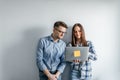 Happy mix-race couple holding laptop computer while standing and celebrating isolated over gray wall background Royalty Free Stock Photo