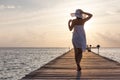 Caucasian woman takes rest at wooden pier to Indian ocean Royalty Free Stock Photo