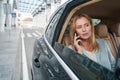 Caucasian woman talking on smartphone in taxi