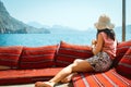 Caucasian woman tourist relax lay on vacation on cruise ship deck enjoy sunny persian gulf panorama with rocky mountains cliffs.