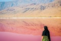 Caucasian woman tourist stand on Maharlu pink salt lake shore. Travel destination Iran in Shiraz