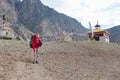 Caucasian woman trekker in Himalayan mountains near stupa, Ladakh, India