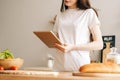 Caucasian woman use tablet computer in the modern kitchen, preparing salad Royalty Free Stock Photo
