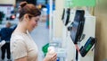 Caucasian woman uses a self-checkout counter. Self-purchase of groceries in the supermarket without a seller Royalty Free Stock Photo