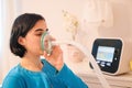 A caucasian woman using a cough assist ventilator mask for deep breaths, respiratory condition