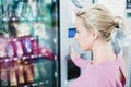 Caucasian woman using a modern vending machine. Her right hand is placed on the dia pad Royalty Free Stock Photo