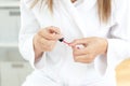 Caucasian woman varnishing her fingernail