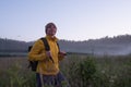 Caucasian woman walking in field alone. Girl in sport clothes hiking with backpack. Royalty Free Stock Photo